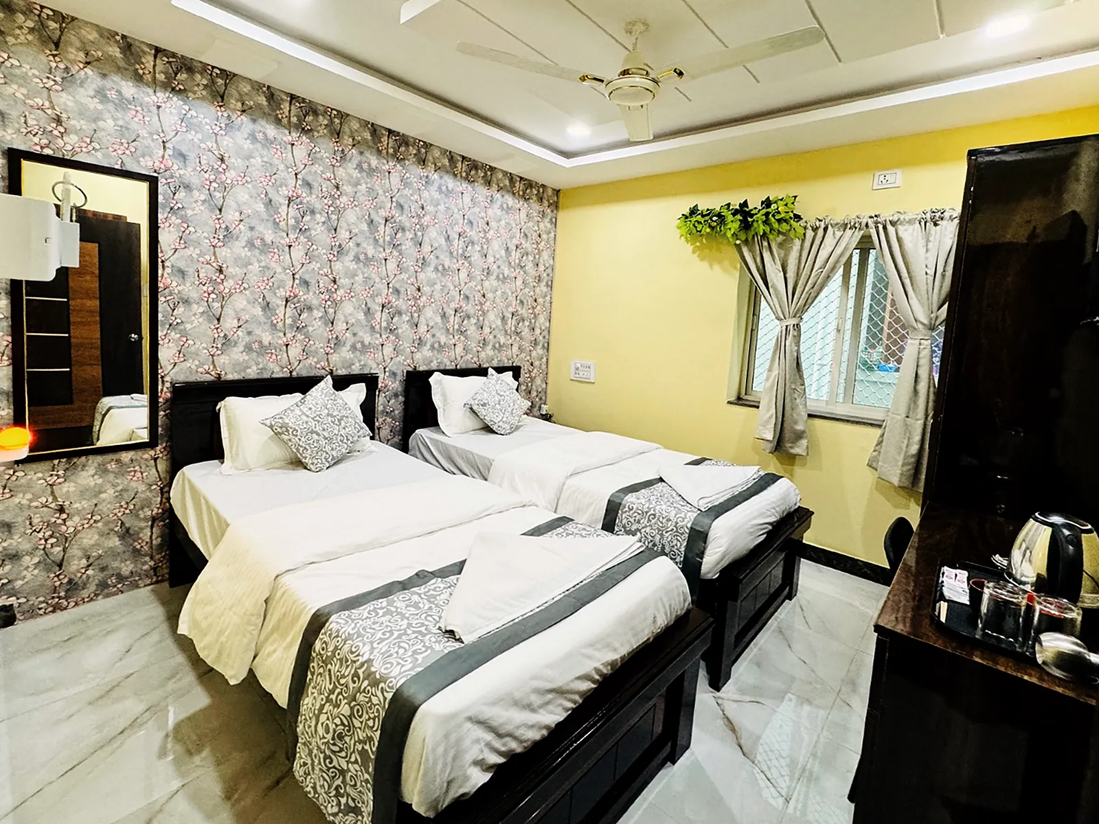 Twin room with a mirror and window at Hotel Hyderabad Pulse
